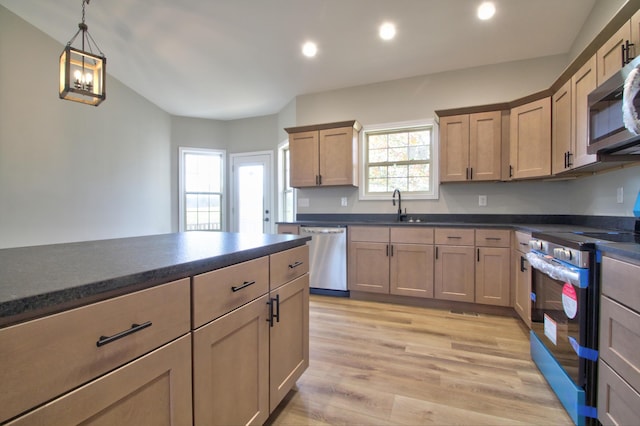 kitchen featuring appliances with stainless steel finishes, light brown cabinetry, light wood-type flooring, decorative light fixtures, and sink