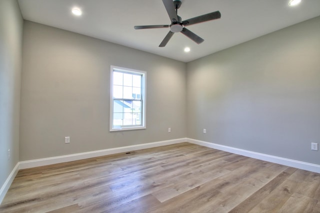 spare room featuring light hardwood / wood-style flooring and ceiling fan