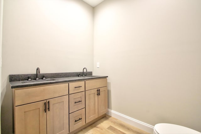 bathroom with toilet, hardwood / wood-style flooring, and vanity