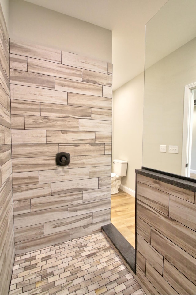 bathroom with hardwood / wood-style flooring and a tile shower