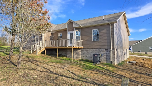 back of house featuring a wooden deck, cooling unit, and a lawn