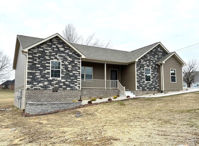 ranch-style home featuring covered porch and a front lawn