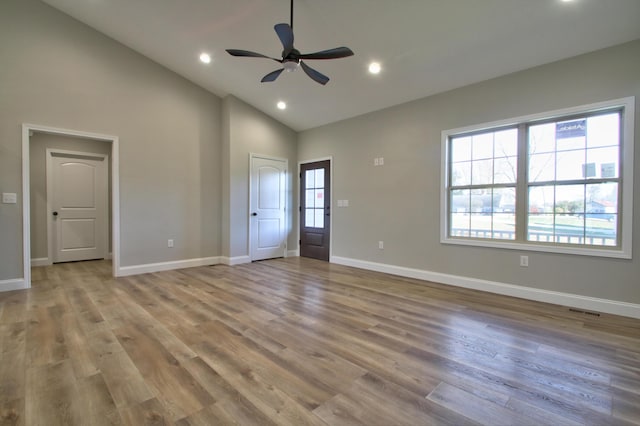 interior space featuring ceiling fan, high vaulted ceiling, and light wood-type flooring