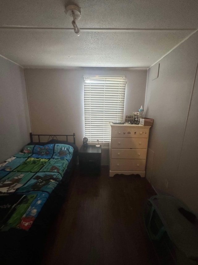 bedroom featuring dark wood-type flooring and a textured ceiling