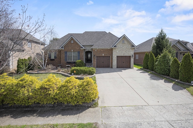 view of front of property featuring driveway, brick siding, an attached garage, and stone siding