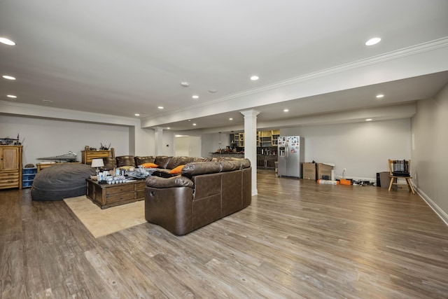 living area with recessed lighting, wood finished floors, baseboards, ornamental molding, and decorative columns