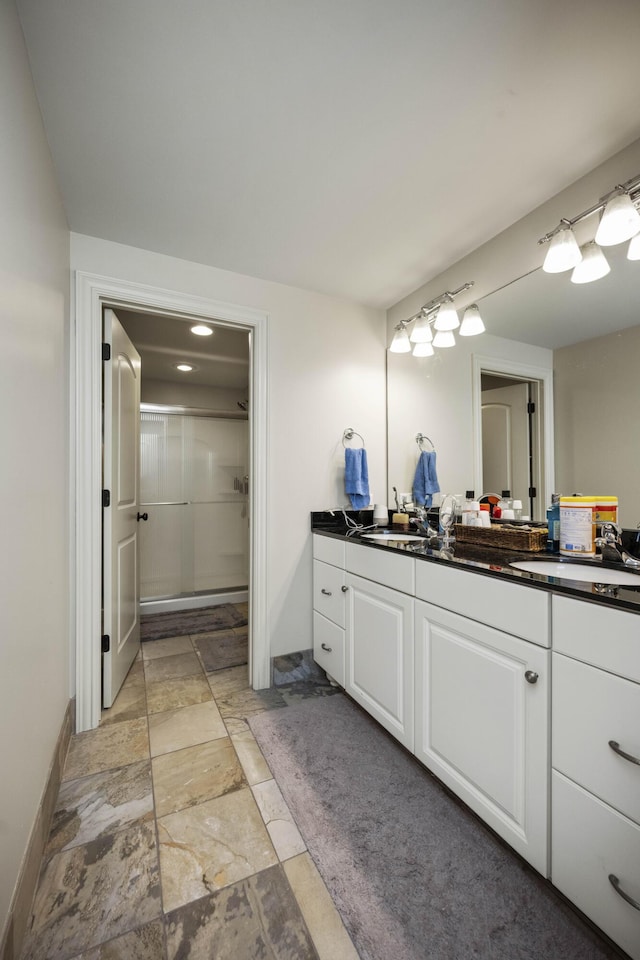 full bathroom featuring walk in shower, vanity, and baseboards