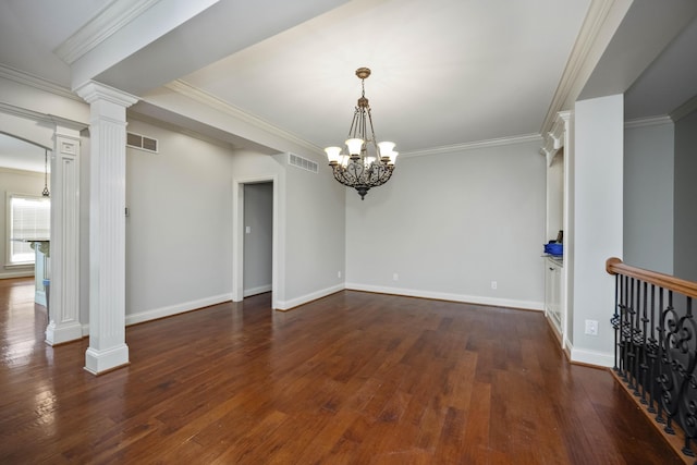 spare room with hardwood / wood-style floors, decorative columns, and visible vents