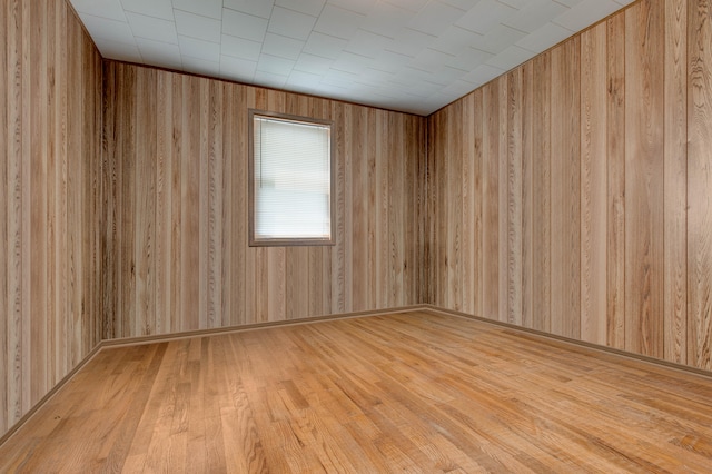 empty room featuring hardwood / wood-style floors and wood walls