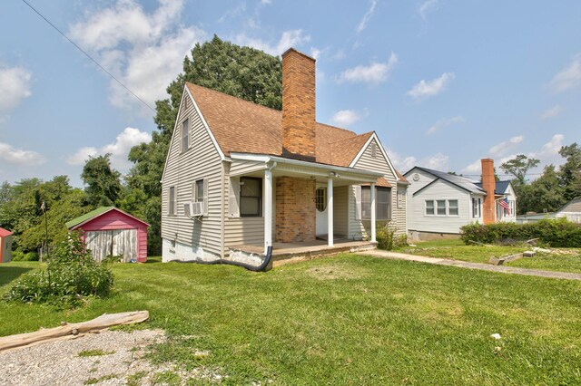 bungalow featuring cooling unit, a storage shed, and a front yard