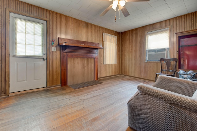 living room with cooling unit, ceiling fan, and light hardwood / wood-style floors