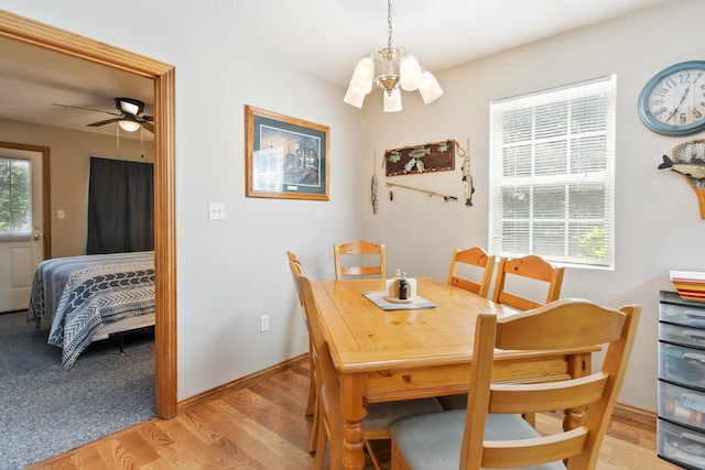 dining space with plenty of natural light, light wood-style floors, baseboards, and a chandelier