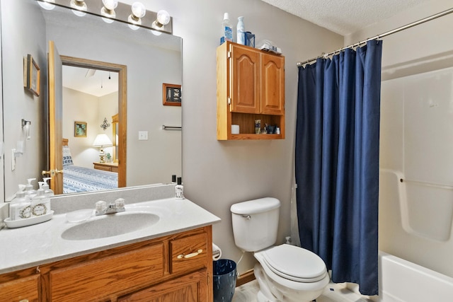 bathroom featuring connected bathroom, toilet, shower / tub combo with curtain, vanity, and a textured ceiling