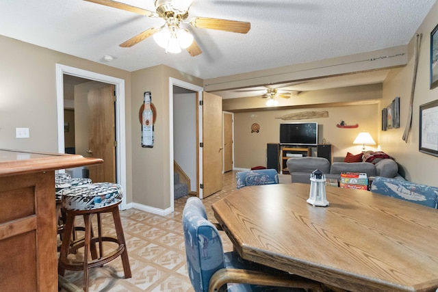 dining space featuring stairway, baseboards, a textured ceiling, and ceiling fan