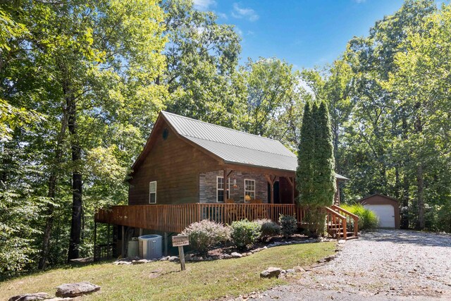 log cabin featuring a garage and an outbuilding