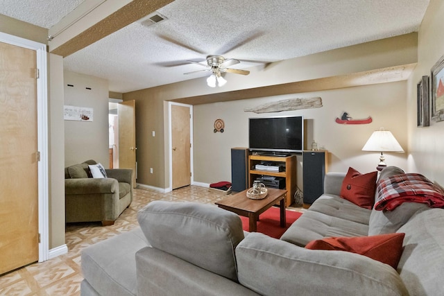 living area featuring a ceiling fan, baseboards, visible vents, light floors, and a textured ceiling