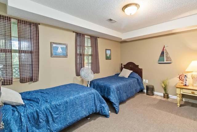 bedroom featuring baseboards, carpet flooring, a textured ceiling, and visible vents