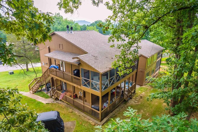 rear view of property featuring a yard and a deck