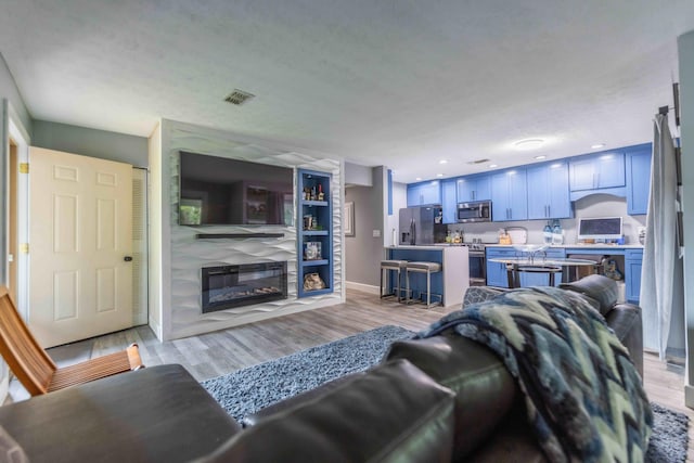 living room featuring a textured ceiling and light wood-type flooring