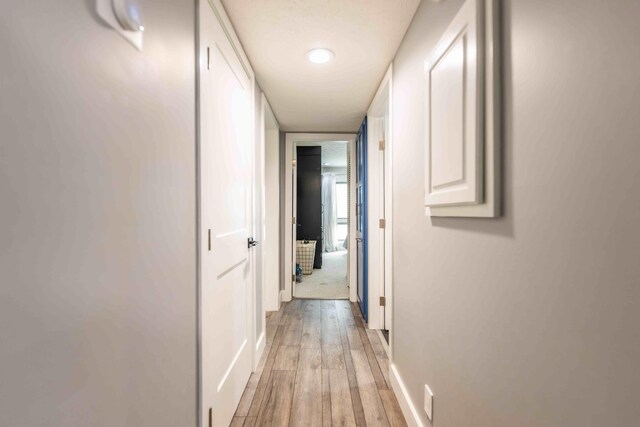 corridor with light hardwood / wood-style flooring