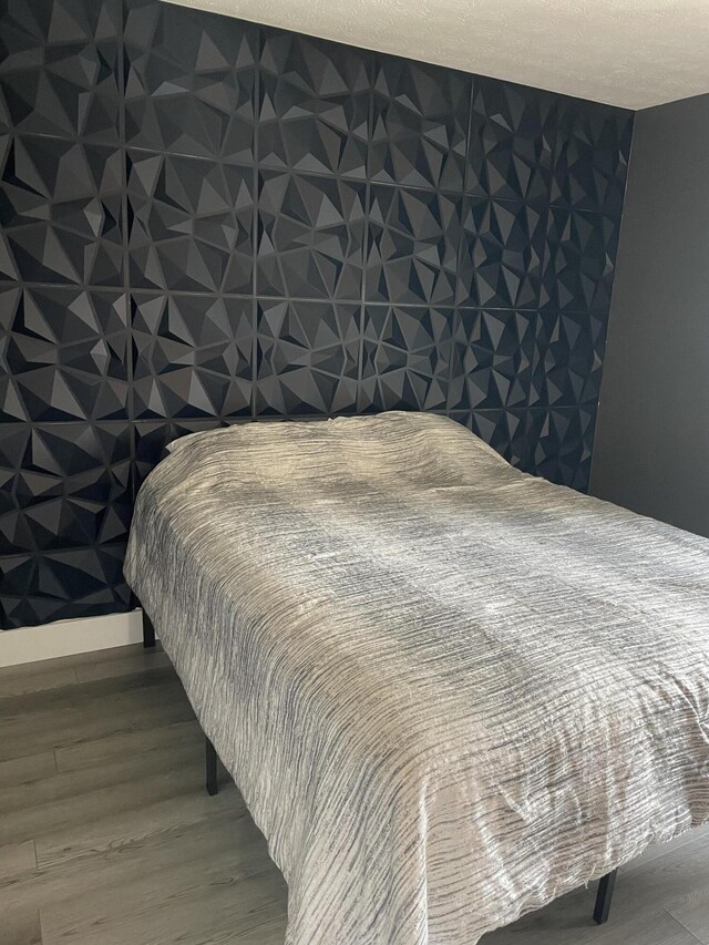 bedroom with hardwood / wood-style flooring and a textured ceiling