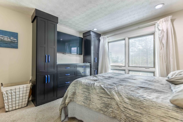 bedroom featuring a textured ceiling and light colored carpet