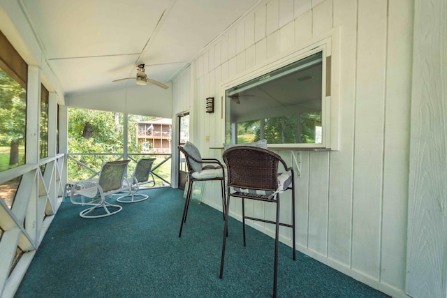 sunroom / solarium featuring ceiling fan, a wealth of natural light, and vaulted ceiling