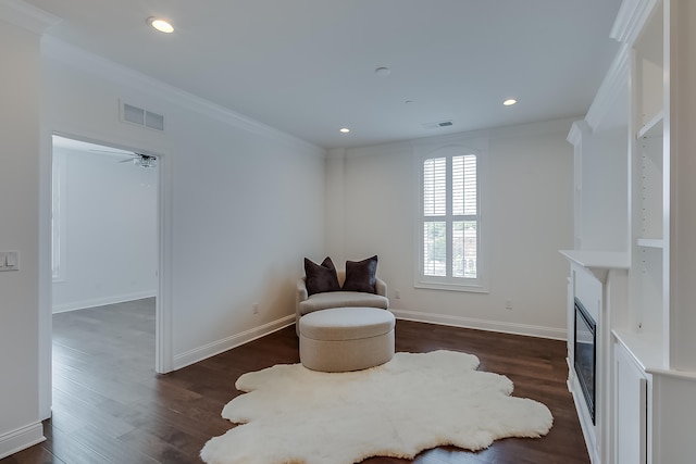 sitting room with dark hardwood / wood-style floors, ceiling fan, and ornamental molding