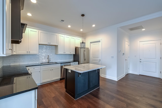 kitchen with sink, hanging light fixtures, dark hardwood / wood-style floors, white cabinets, and appliances with stainless steel finishes