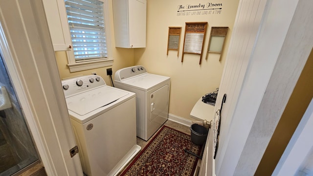 clothes washing area with independent washer and dryer and cabinets