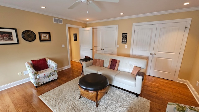 living room with ceiling fan, crown molding, and wood-type flooring