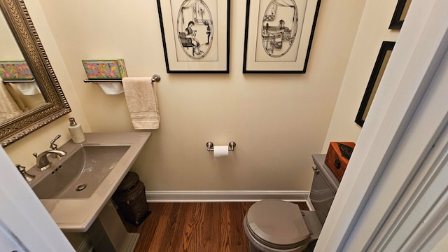 bathroom featuring toilet, wood-type flooring, and sink