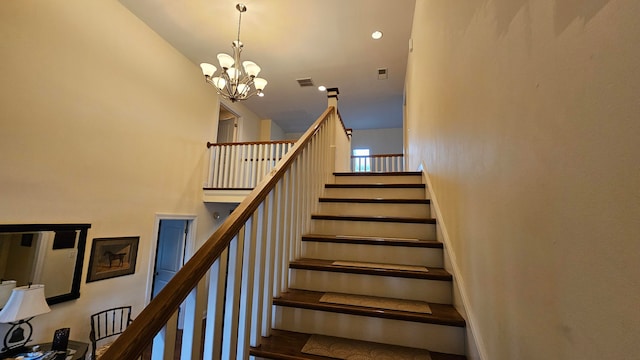 stairs with a notable chandelier