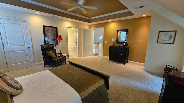 carpeted bedroom featuring ceiling fan, a raised ceiling, and ornamental molding