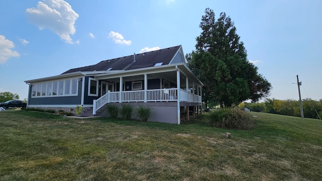 rear view of property with a yard and a porch