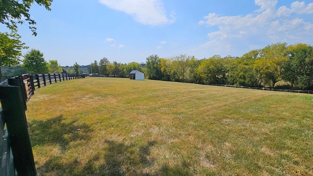 view of yard featuring a rural view and a storage unit