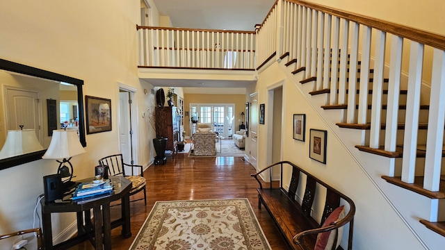 foyer featuring dark wood-type flooring and a towering ceiling