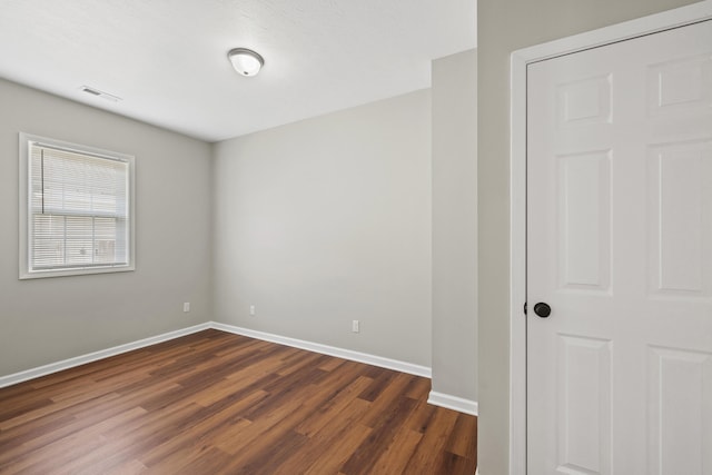 unfurnished room with dark hardwood / wood-style floors