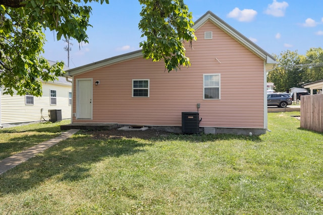 back of property with cooling unit and a yard