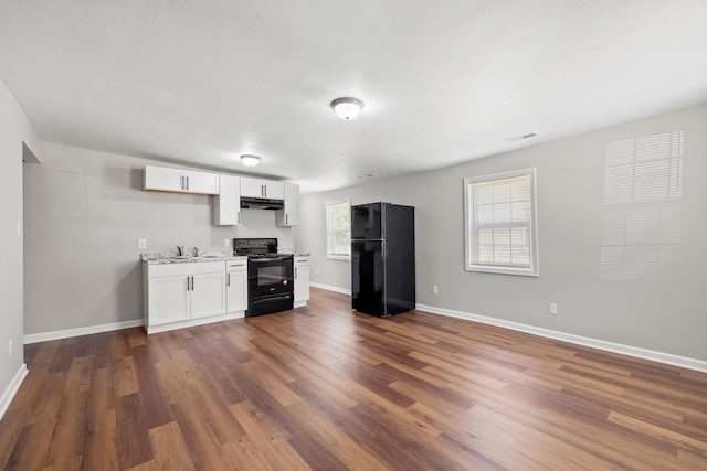 kitchen with white cabinetry, sink, black appliances, dark wood-type flooring, and a textured ceiling