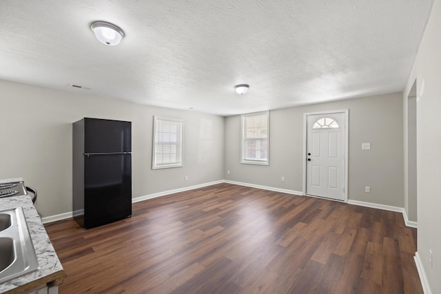 foyer entrance with a textured ceiling, sink, and dark hardwood / wood-style flooring