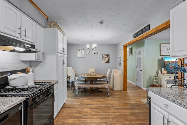 kitchen with dark hardwood / wood-style flooring, a textured ceiling, black range with gas cooktop, and a chandelier