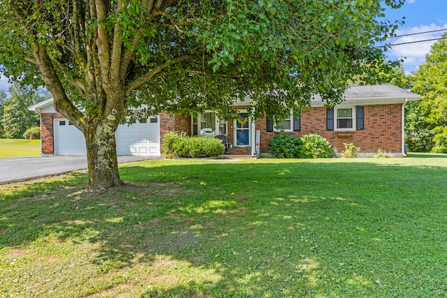 view of property hidden behind natural elements with a garage and a front lawn