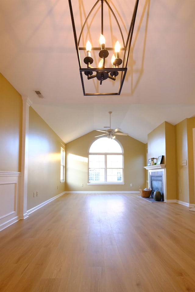 unfurnished living room featuring lofted ceiling, wood finished floors, a fireplace, and visible vents