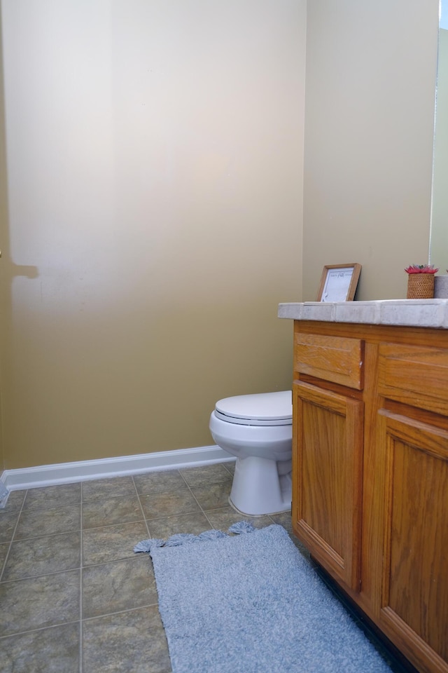 half bathroom featuring toilet and baseboards