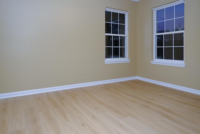 empty room featuring baseboards and wood finished floors