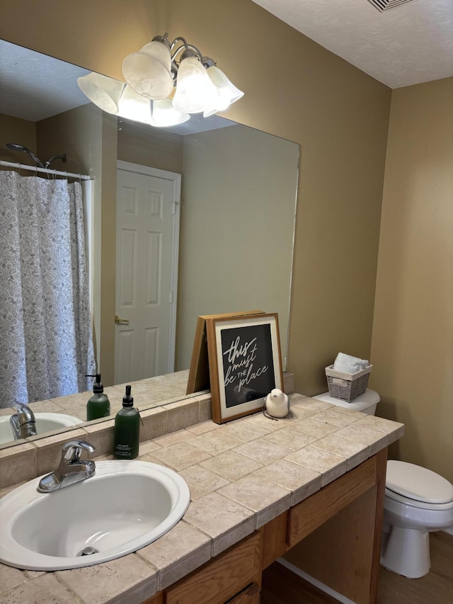 bathroom featuring vanity, curtained shower, toilet, and visible vents