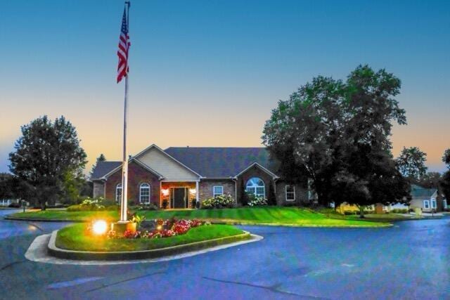 view of front of property with a water view and a lawn