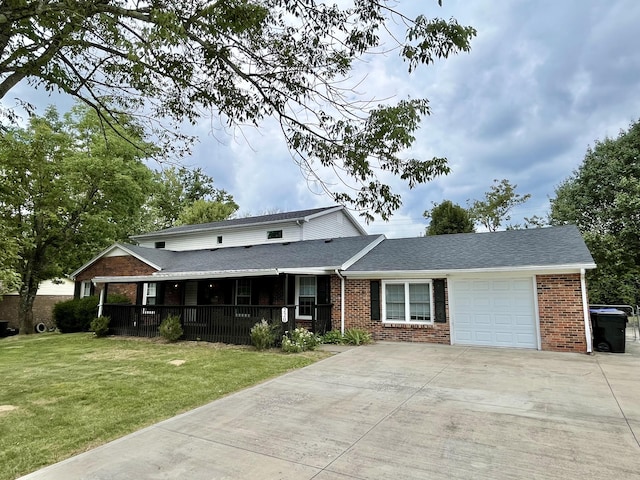 view of front of house featuring a garage, a front yard, concrete driveway, and brick siding