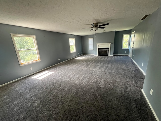 unfurnished living room with carpet flooring, ceiling fan, and plenty of natural light